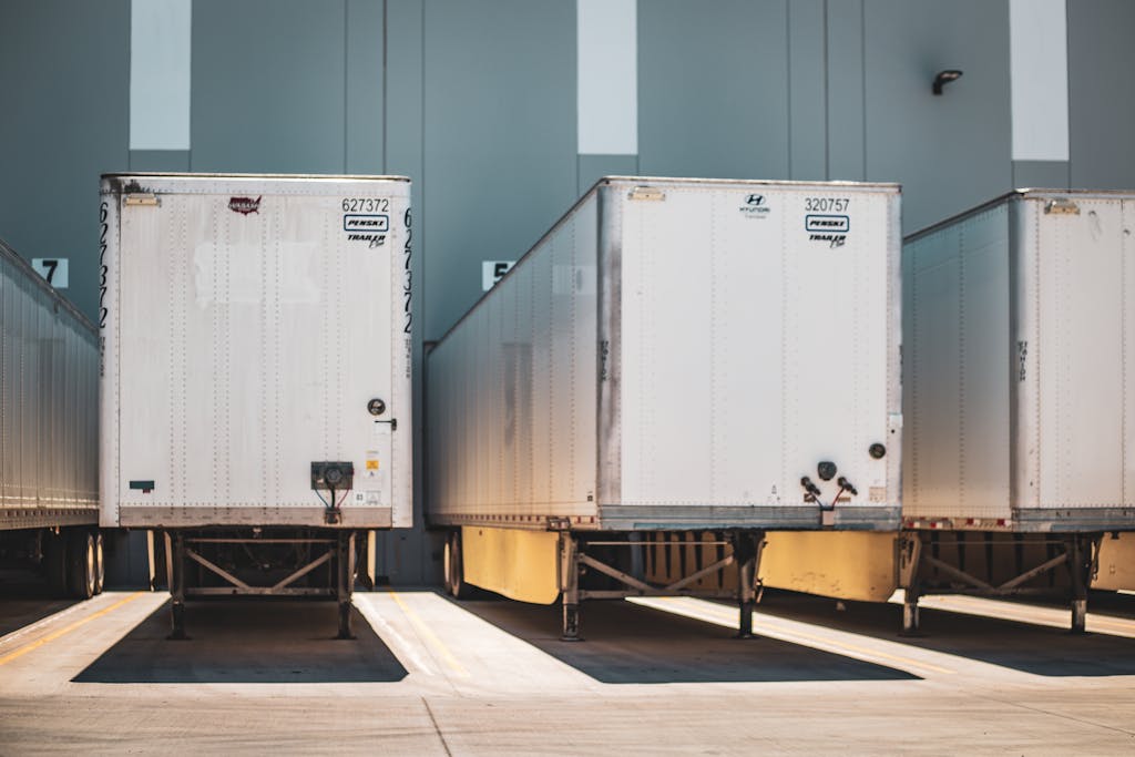 A row of freight trailers parked at a commercial loading dock, emphasizing transportation and logistics.